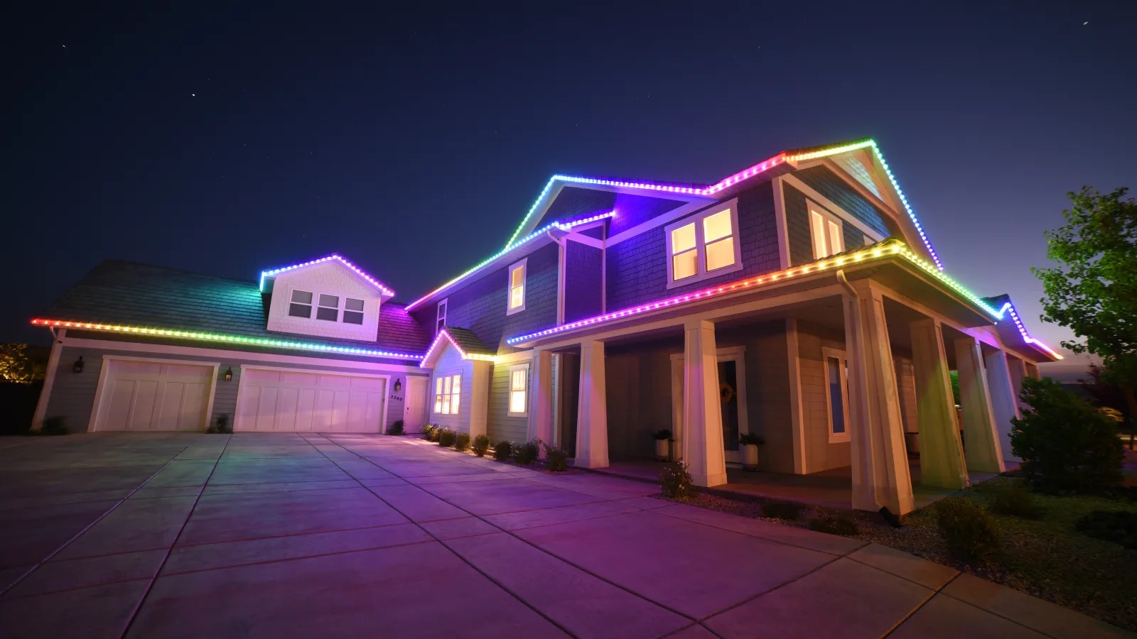 Home lit in a full rainbow gradient running the length of the roofline